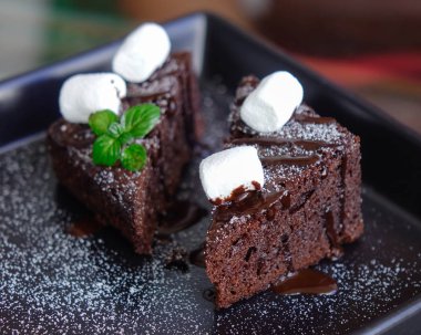 Kesilmiş parça ve ahşap arka plan üzerinde bıçak ile lezzetli çikolatalı kek. Yakın çekim.