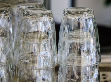 Cam bardak ahşap mutfak masasında üzerinde baş aşağı. Yakın çekim.