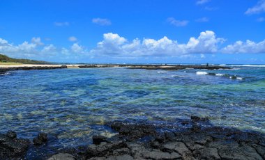 Güneşli bir günde yaz - siyah kayalar ile mavi deniz, deniz manzarası.
