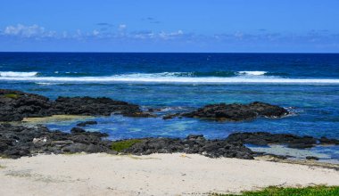 Güneşli bir günde yaz - birçok siyah taşlarla güzel mavi deniz, deniz manzarası.