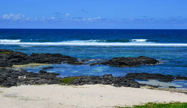 Güneşli bir günde yaz - birçok siyah taşlarla güzel mavi deniz, deniz manzarası.