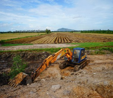 Mekong Delta, Vietnam - 8 Ağustos 2016. Bir ekskavatör Mekong Delta, Vietnam için pirinç alan üzerinde çalışıyor. 2.6 milyon ha Mekong Deltası'nda tarım için kullanılır.