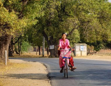 Bagan, Myanmar - 19 Şubat 2016. Bagan, Myanmar de kırsal yol bisikleti bir Birmanya kız. Bagan olduğunu ev sahipliği Budist tapınaklar, pagodadan ve stupas en büyük ve en yoğun konsantrasyon.