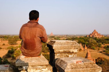Bir turist oturan ve tapınaklar Bagan, Myanmar içinde arıyorum. Bir antik kent ve Asias en önemli arkeolojik Bagan biridir.