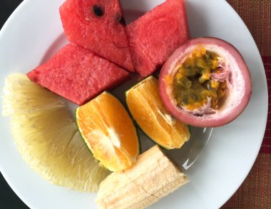 Beyaz tabakta meyve kesiyorum. 