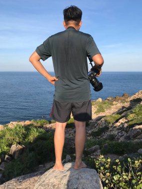 Asyalı adam mavi denizin tadını çıkarıyor. 