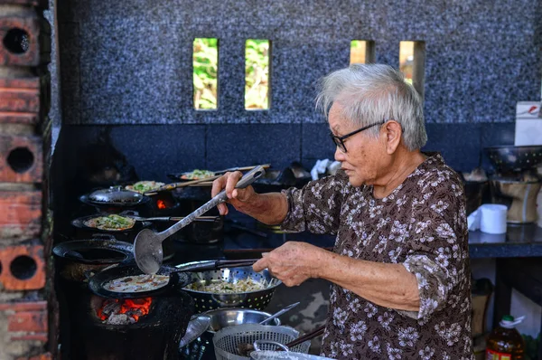 Una anciana cocinando panqueques vietnamitas — Foto de Stock
