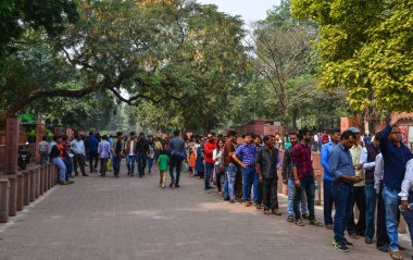 Yerel halk Taj Mahal 'e girmek için kuyrukta bekliyor. 