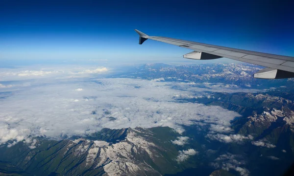 Uitzicht van vliegtuig naar bergen en wolken — Stockfoto