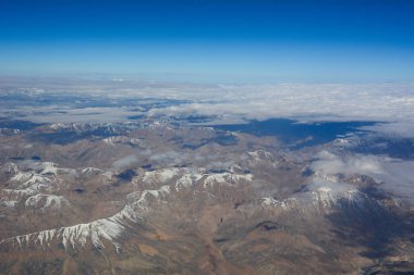 Kar dağlarının tepelerinin üstündeki hava manzarası 