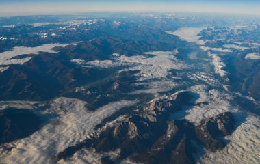 Dağ zirvelerindeki bulutların üstündeki hava manzarası