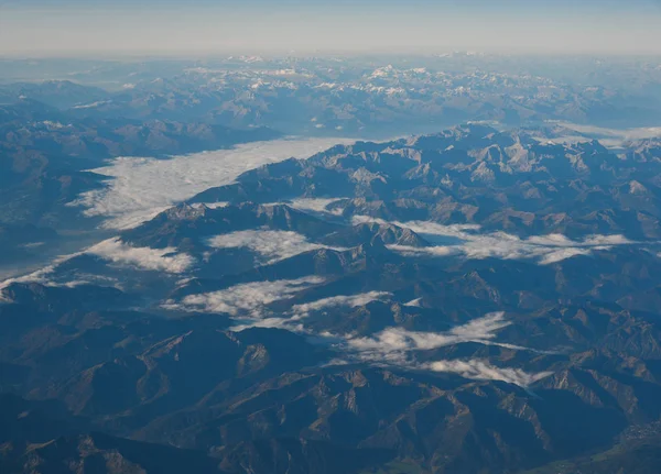 Dağ zirvelerindeki bulutların üstündeki hava manzarası