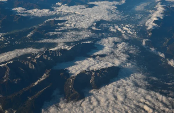 Luchtfoto boven de wolken op bergtoppen — Stockfoto