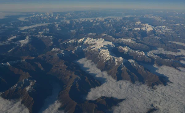 Luchtfoto boven de wolken op bergtoppen — Stockfoto