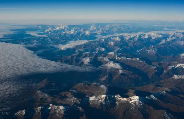 Luchtfoto boven de wolken op bergtoppen — Stockfoto