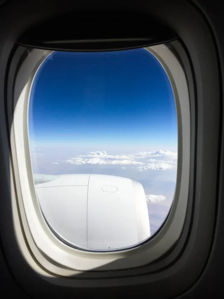 Janela de avião com fundo azul céu — Fotografia de Stock