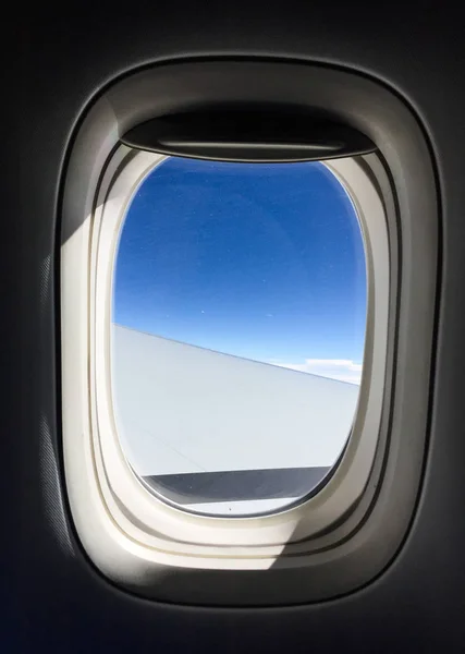 Janela de avião com fundo azul céu — Fotografia de Stock