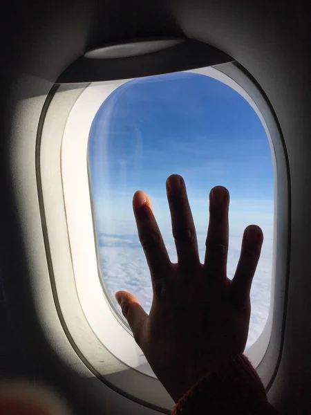 Uma mão sobre a janela do avião — Fotografia de Stock