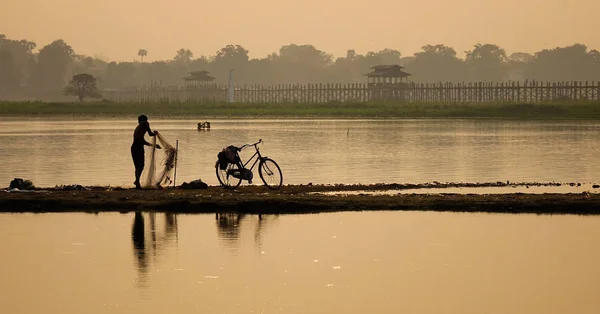 Fisherman working on the lake in early morning — Stock Photo, Image