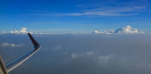 Vleugel van het vliegtuig boven witte wolken — Stockfoto