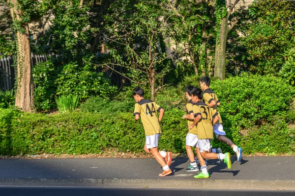 Młodzi chłopcy biegną ulicą Tokio, Japonia — Zdjęcie stockowe