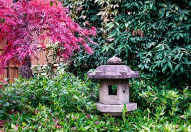 Küçük sonbahar bahçesinde taş fener. 