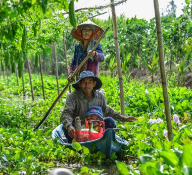 Mekong Nehri 'nde ahşap tekne kullanan insanlar.
