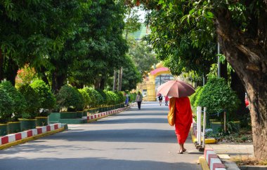 Vientiane, Laos - 29 Ocak 2020. Vientiane 'de sokakta yürüyen bir keşiş. Lao Budizmi, Theravada Budizmi 'nin eşsiz bir versiyonudur ve etnik Lao kültürünün temelini oluşturur..