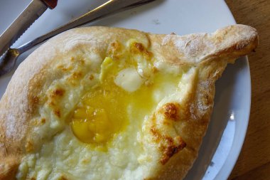 Yerel bir restoranda öğle yemeği için Adjaruli Khachapuri (Gürcistan Peynirli Ekmek).