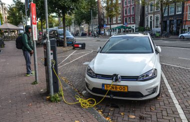 Amsterdam, Hollanda - 7 Ekim 2018. Amsterdam, Hollanda 'nın merkezindeki caddede şarj noktasından tipik bir elektrikli araba..