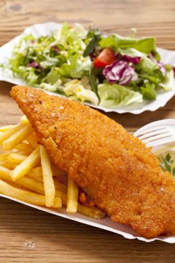 Kızarmış balık ve cips bir kağıt tepsisi üzerinde