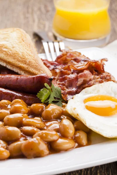Kompletní anglická snídaně s slanina, klobása, sázené vejce, zapeč — Stock fotografie