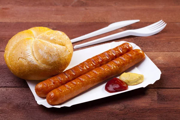 Salsicha assada com pão servido em uma bandeja de papel — Fotografia de Stock