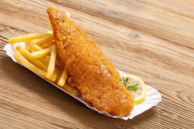 Kızarmış balık ve cips bir kağıt tepsisi üzerinde