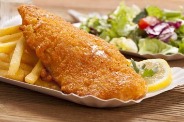Kızarmış balık ve cips bir kağıt tepsisi üzerinde