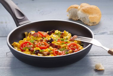 Pastırma, soğan ve domates ile bir tavada omlet serpilir