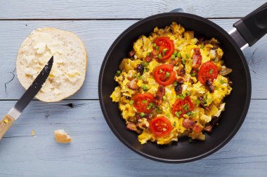 Pastırma, soğan ve domates ile bir tavada omlet serpilir