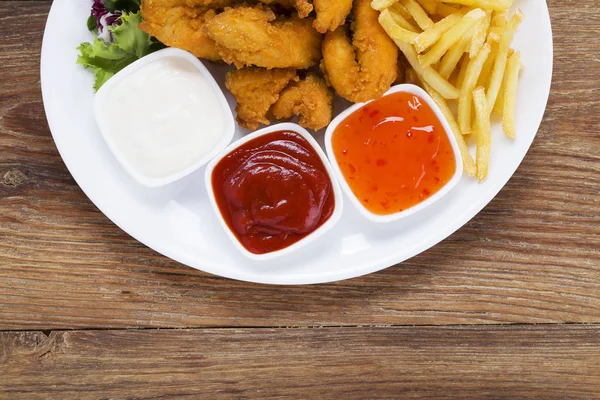 Nuggets ve bir plaka üzerinde fiş daldırma ve salata ile servis — Stok fotoğraf