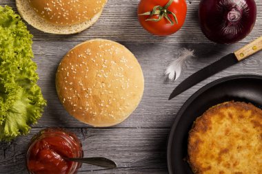 Ev yapımı tavuk burger marul, domates ve soğan ile