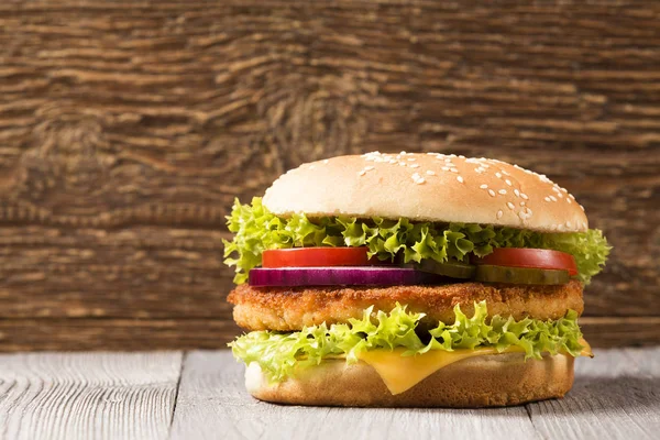 Chicken burger with cheese, lettuce, tomato and onion — Stock Photo, Image