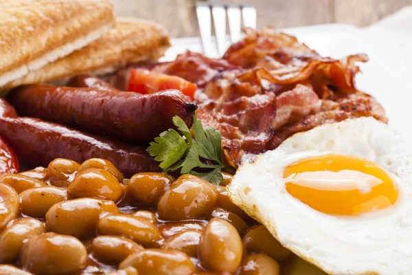 Повний англійський сніданок з беконом, сосискою, смаженим яйцем, запеченою квасолею — стокове фото