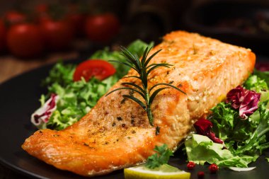 Fırında somon taze sebzelerle servis edilir..