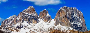 Dolomitlerin tepeleri - panorama. Mavi gökyüzüyle güneşli bir öğleden sonra