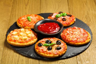 Taş üstünde mini pizzaların karışımı.