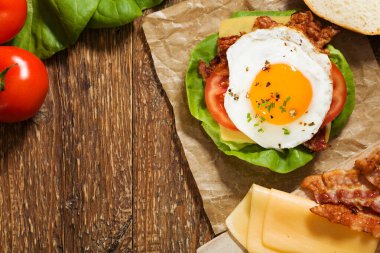Kızarmış yumurta, pastırma, peynir ve sebzeli sandviç..