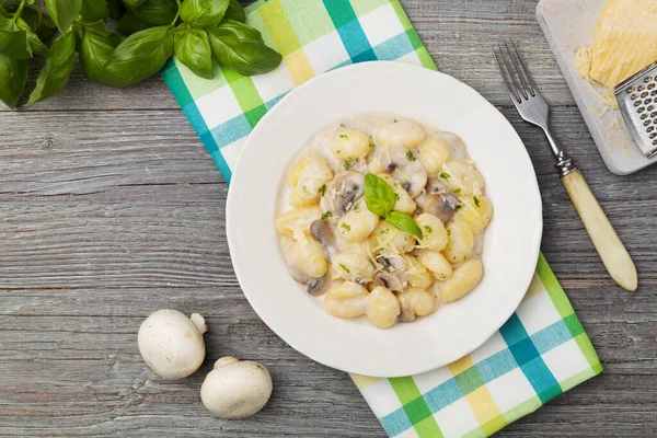 Portie gnocchi met champignonsaus en kaas. — Stockfoto