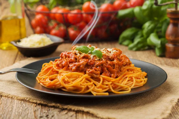 Köstliche Spaghetti auf einem schwarzen Teller serviert — Stockfoto