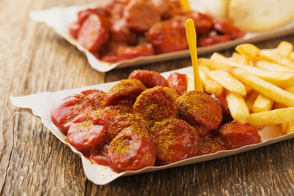 Currywurst alemán tradicional, servido con patatas fritas en p desechable — Foto de Stock