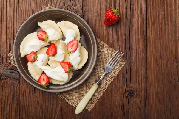 Delicious dumplings with fresh strawberries served with whipped — Stock Photo, Image