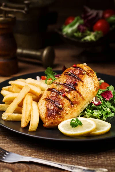 Grilled chicken breast with green salad and french fries. — Stock Photo, Image